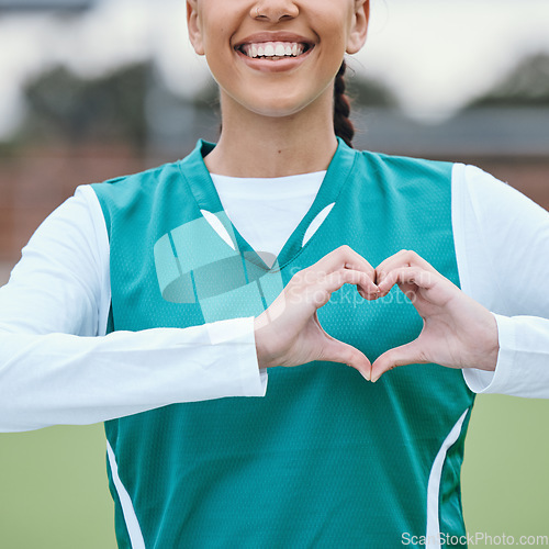 Image of Sports, heart hands or happy athlete on field for fitness, exercise or workout for cardiovascular health. Love sign, hand gesture or healthy woman in a training game for wellness or hockey practice