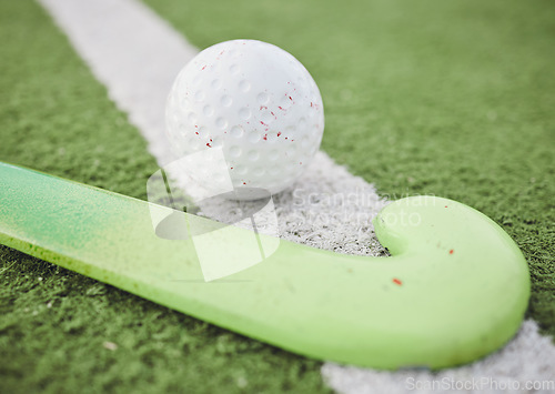Image of Hockey, stick and ball on green, field or pitch with sports equipment for game, competition or match on ground or floor. Artificial grass, turf or gear for training sport championship on astroturf