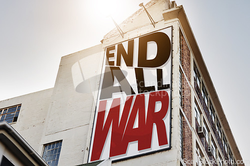 Image of Building, billboard and poster with information on wall with war, propaganda or advertising activism campaign in city. End, conflict and sign or banner to protest politics, violence or global crisis