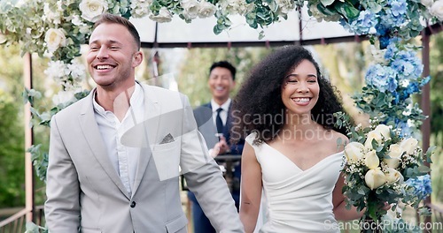 Image of Couple, wedding and walk with flower confetti for event, celebration and outdoor in nature. Girl, happy interracial marriage and floral bouquet in park, holding hands or fist in air, pride or party