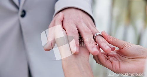 Image of Couple, holding hands and ring for marriage, wedding or ceremony for commitment, love or support. Closeup of people getting married, vows or accessory for symbol of bond, relationship or partnership