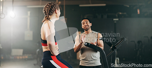 Image of Woman, cycling and personal trainer in high five, motivation or fitness workout, exercise and training at gym. Man coaching female person on bicycle, machine or equipment in cardio at health club