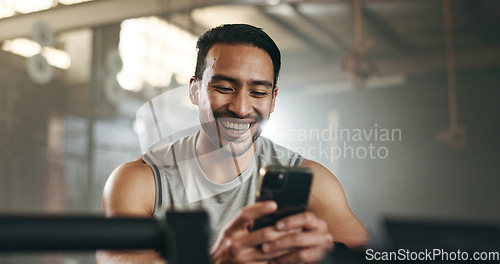 Image of Happy asian man, phone and fitness on break in social media, communication or networking at gym. Active male person smile for online texting or chatting on mobile smartphone app at indoor health club