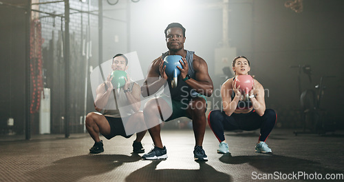 Image of People, fitness and squat at gym with kettlebell in workout class, exercise or training together. Personal trainer with active group in sports, lose weight or muscle endurance at indoor health club