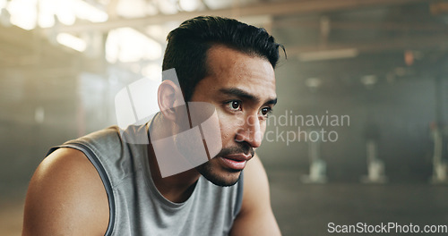 Image of Fitness, face and breathing with a tired man in the gym, resting after an intense workout. Exercise, sweating and fatigue with a young athlete in recovery from training for health or wellness