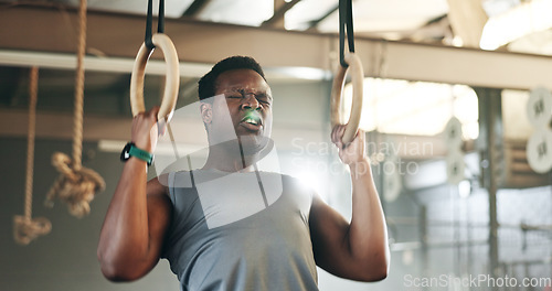 Image of Sports, gymnastics and black man doing pull up exercise for arm muscle training or workout in gym. Fitness, bodybuilding and African male athlete doing an intense strength challenge in health center.