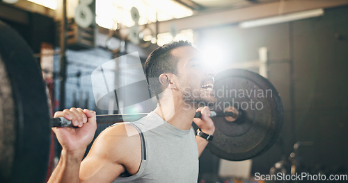 Image of Man at gym, weight lifting and barbell with focus on muscle building endurance, strong body and balance power in fitness. Commitment, motivation and bodybuilder in workout for health and wellness.