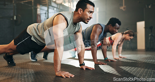 Image of Gym, group fitness and push up exercise for power, sports challenge and muscle on ground. Serious asian man, bodybuilder and performance training on floor with friends, workout class or strong people