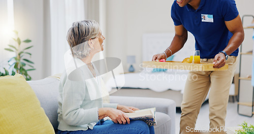 Image of Breakfast, assisted living and retirement with a mature woman on a sofa in the living room of her home. Morning, food and a nurse black man serving a meal to an elderly patient in a care facility