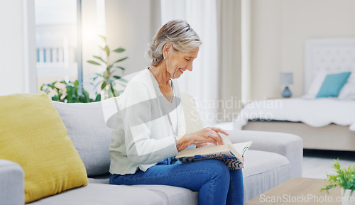 Image of Senior woman, book and reading to relax in living room for story, novel and knowledge. Elderly female person, books and focus in lounge for retirement break, literature and hobby on sofa at home