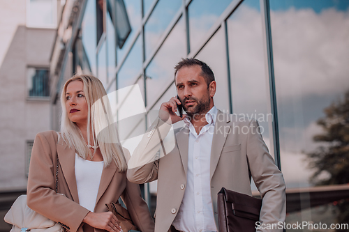 Image of Modern business couple after a long day's work, walking together towards the comfort of their home, embodying the perfect blend of professional success and personal contentment.