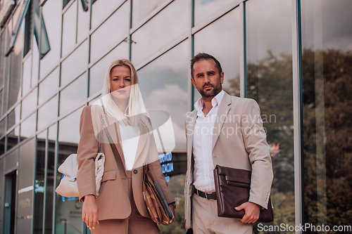 Image of Modern business couple after a long day's work, walking together towards the comfort of their home, embodying the perfect blend of professional success and personal contentment.