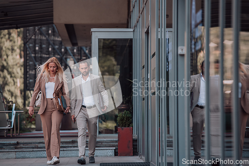 Image of Modern business couple after a long day's work, walking together towards the comfort of their home, embodying the perfect blend of professional success and personal contentment.