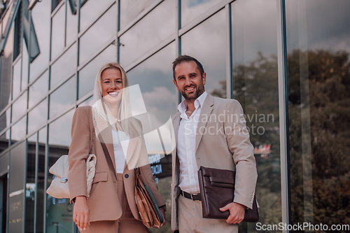 Image of Modern business couple after a long day's work, walking together towards the comfort of their home, embodying the perfect blend of professional success and personal contentment.