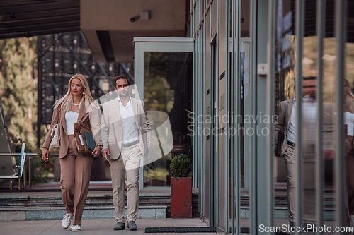 Image of Modern business couple after a long day's work, walking together towards the comfort of their home, embodying the perfect blend of professional success and personal contentment.