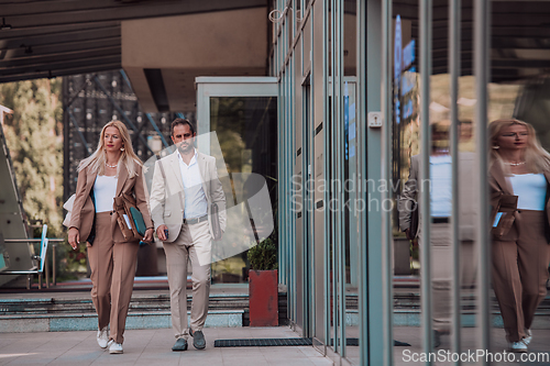 Image of Modern business couple after a long day's work, walking together towards the comfort of their home, embodying the perfect blend of professional success and personal contentment.