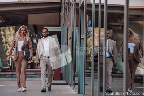 Image of Modern business couple after a long day's work, walking together towards the comfort of their home, embodying the perfect blend of professional success and personal contentment.