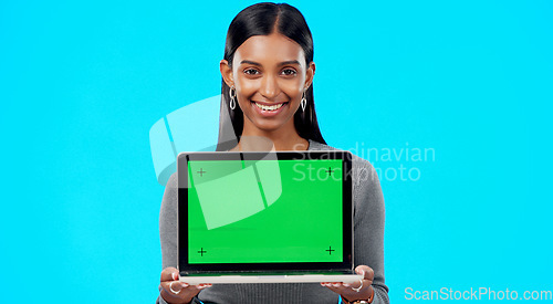 Image of Portrait, woman and green screen space on laptop for advertising, sign up offer and info in studio. Happy indian model, computer and tracking markers for newsletter, review or deal on blue background