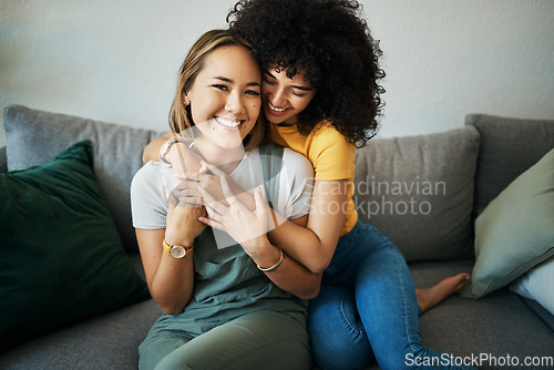 Image of Lgbt, couple and portrait of hug on sofa in home, living room or apartment with love, support and happiness. Lesbian, women and embrace together with smile on face on lounge couch in new house