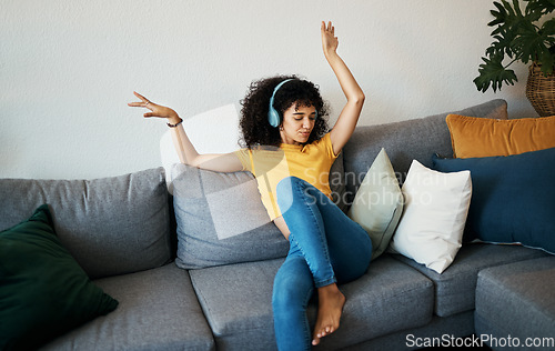Image of Music, headphones and woman dance on a sofa with podcast, album or audio track at home. Radio, earphones and female person having fun in living room with feel good subscription, streaming or freedom