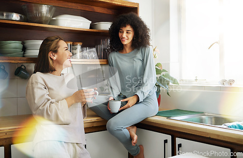 Image of Coffee, smile and lesbian couple in home kitchen, bonding and communication. Drink tea, gay women and happy girls in the morning at breakfast together in interracial relationship, care and LGBT love