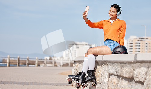 Image of Skating, woman and selfie outdoor for social media, internet post or profile picture in nature. Sports, person and headphones by ocean, park or sea for relax, freedom and happiness with roller skates