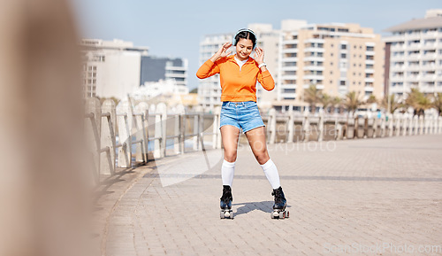 Image of Girl, rollerskates and smile with headphones, boardwalk and fun by ocean, sea and outdoors for hobby. Active person, skating and sport in summer, music and gear for safety, energy and happy in summer