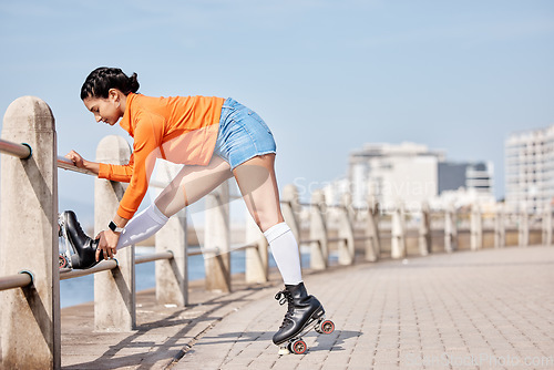 Image of Woman, roller skates and outdoor in park, stretching legs and training for contest, fitness or health by ocean. Gen z girl, skating and walk for exercise, workout or metro road by sea in Cape Town