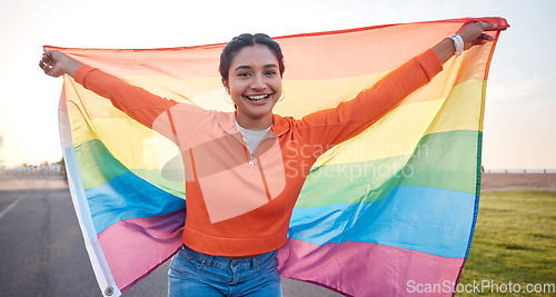 Image of Woman, portrait and rainbow pride flag with smile outdoor for peace, equality and community support. Queer lgbtq person, sexuality and human rights to respect freedom happiness, identity or inclusion