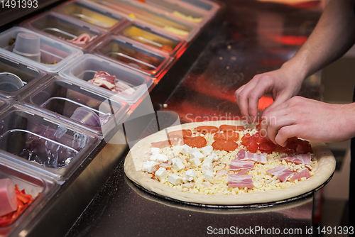 Image of making pizza at kitchen of pizzeria