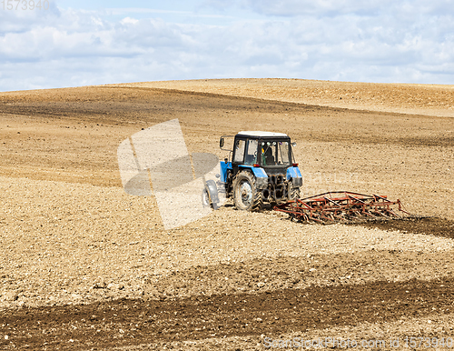 Image of an old tractor plows the soil