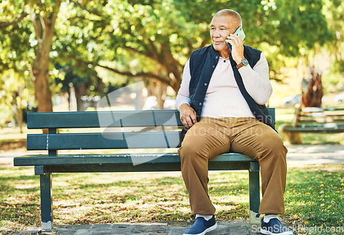 Image of Senior man, phone call and park with conversation and bench outdoor with communication. Nature, discussion and mobile networking with an elderly male person speaking and listening in urban garden