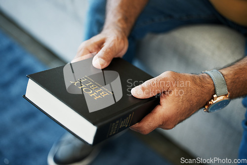 Image of Bible, book and hands of man in home with study of Christian faith, religion or spirituality knowledge. Holy, worship and person with gospel, scripture or learning about God or story of Jesus Christ