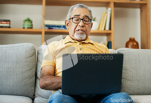 Image of Typing, senior man and laptop on sofa in home with online research in living room or streaming video, movies or tv show. Elderly, person or writing on computer in retirement for blog or communication