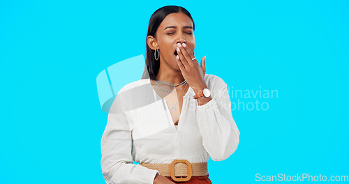 Image of Woman, yawn and hand on mouth, tired and studio by blue background, alone or isolated. Overworked person, burnout and low energy for deadlines, exhausted and fatigue or lazy for nap, sleep and rest