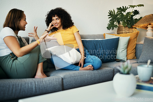 Image of Women, friends and conversation in a home with gossip, discussion and happy in a living room. Couch, smile and people on a sofa with gossip or social together in a house lounge with speaking together