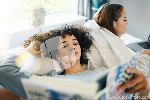 Image of Relax, morning and a lesbian couple reading in bed while together in their home on the weekend. Gay, book and an lgbt woman with her girlfriend in the bedroom for love, calm or bonding in pajamas