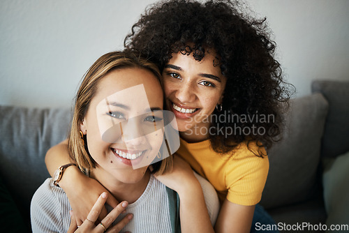 Image of Lesbian, couple and portrait of hug on sofa in home, living room or apartment with love, support and happiness. Lgbt, women and profile picture together on lounge couch with smile on face in house