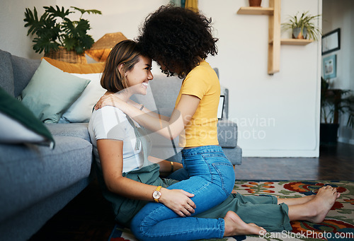 Image of Lgbtq, couple and love with hug on a living room floor in new home with smile of lesbian women. Gay marriage, happy and together with care and support in a lounge with embrace sitting on the ground