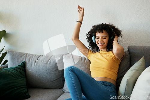Image of Headphones, music and woman dance on a sofa with podcast, album or audio track at home. Radio, earphones and female person having fun in living room with feel good subscription, streaming or freedom