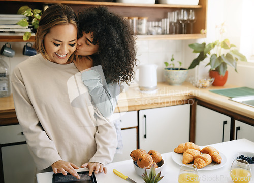 Image of Lesbian, couple and kiss in kitchen with breakfast in morning together with nutrition, love and support in home. Lgbt, women or cooking with food, juice and preparing healthy diet on counter in house