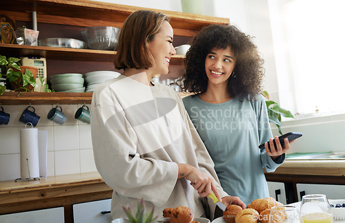 Image of Lesbian, couple and women with phone and cooking with happiness in kitchen for breakfast and nutrition in morning. Food, people and smile with romance in home or face for wellness, lgbt or love