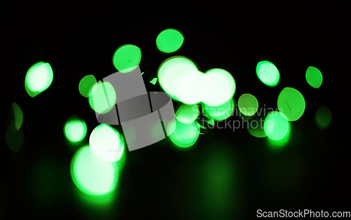 Image of Green, sparkles and bokeh in a studio with dark background for celebration, event or party. Confetti, glitter and color lights for magic, shine or glow for festive by black backdrop with mockup.