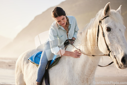 Image of Beach, equestrian and woman riding her horse outdoor on a summer morning for training or practice. Nature, sunset and a young rider on horseback with her pet animal by the ocean or sea to relax