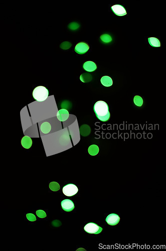 Image of Green light, bokeh and shine on black background isolated on a mockup space. Blur, dark backdrop and defocused glow, sparkle or glitter at night for Christmas, holiday or party with magic color dots