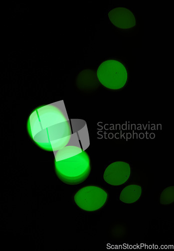 Image of Green light, bokeh and glow on dark background on a mockup space. Blur, black backdrop and defocused shine, sparkle or abstract glitter at night for Christmas, holiday or party with magic color dots