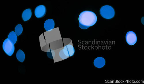 Image of Blue, lights and bokeh in a studio with dark background for celebration, event or party. Confetti, glitter and color sparkles for magic, shine or glow for festive by black backdrop with mockup.