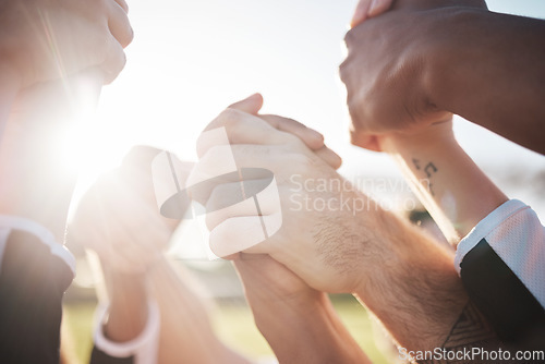 Image of Holding hands in air, solidarity and support in team, group of people outdoor with sunshine, lens flare and winner. Celebration, mission and partnership with community, closeup of synergy and success