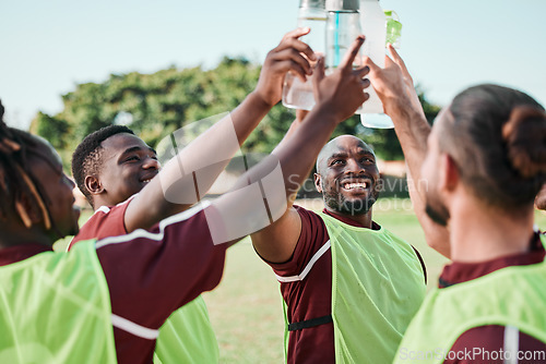 Image of Soccer team, water bottle and cheers with teamwork, achievement and community on grass field. Fitness, workout and sport training of men group with smile and celebration from game outdoor with drink