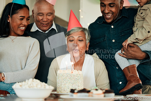Image of Happy birthday, candles or grandma in home for a family celebration, bond or growth together. Blow, senior lady or excited grandparents with cake, support or child at a fun party or special event